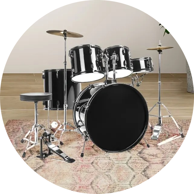 A collection of drums and percussion instruments arranged on a soft surface, including a snare drum, cymbal, and small hand drum.