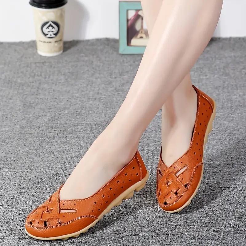 A pair of comfortable women's loafers or slip-on shoes in a neutral color, shown on a clean background, with soft natural lighting highlighting the sleek design and cushioned insole.