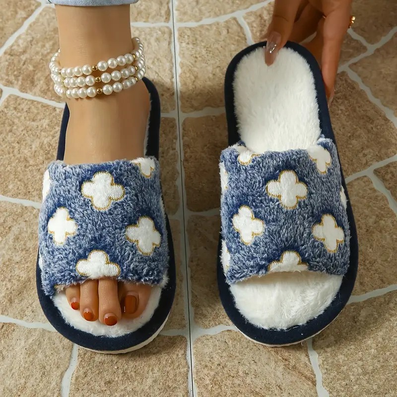 A pair of plush women's slippers resting on a soft rug near a cozy armchair.